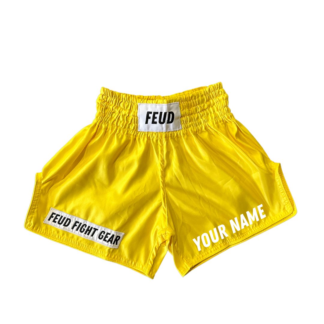 Retro-style yellow Thai boxing shorts, customizable left leg