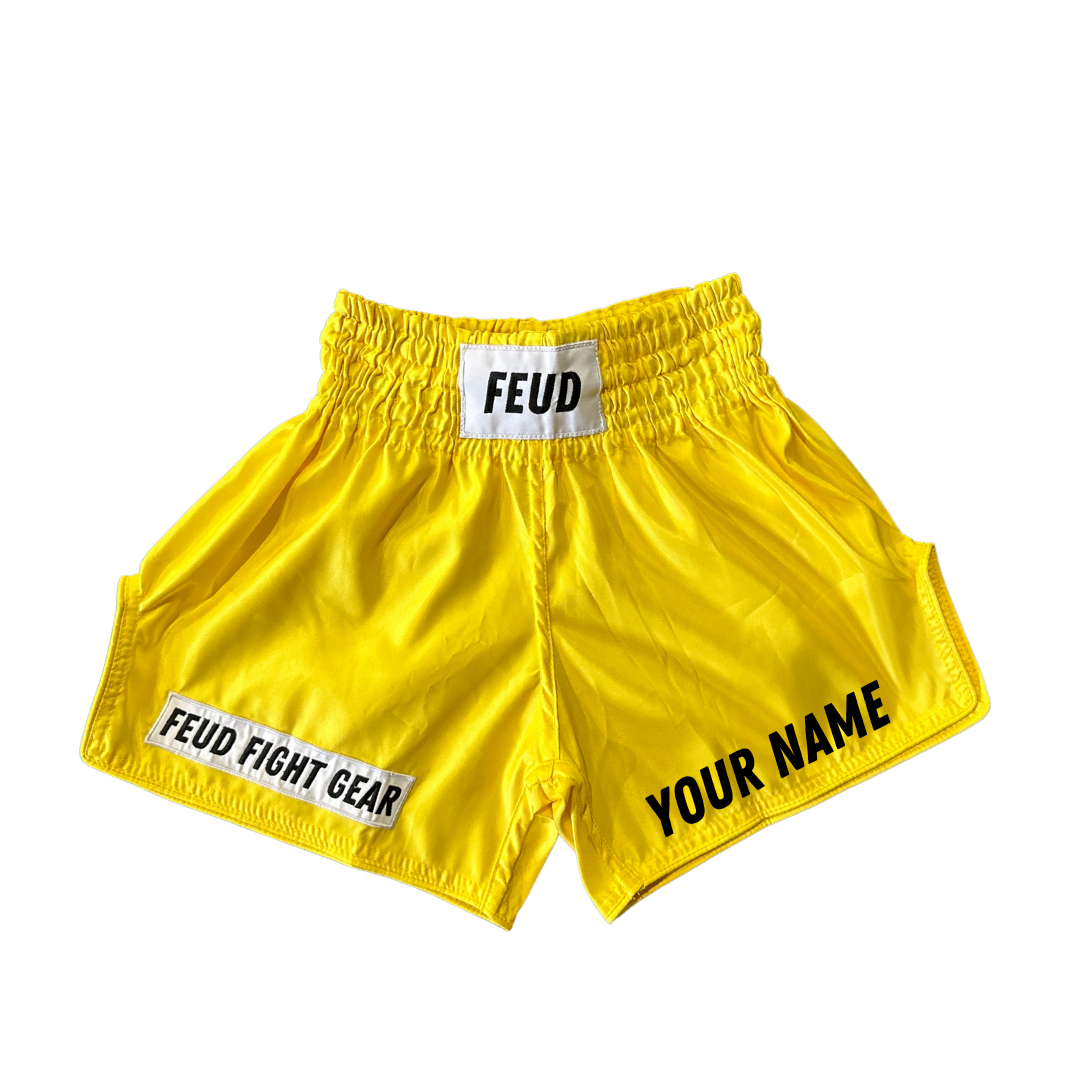 Retro-style yellow Thai boxing shorts, customizable left leg black